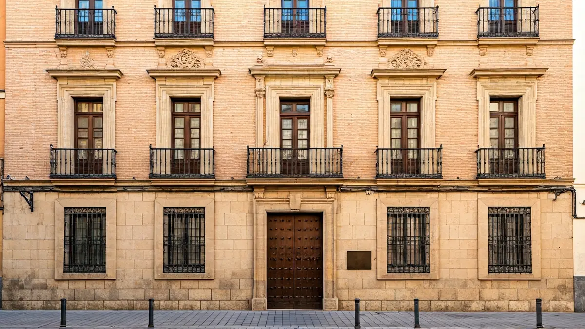 Fachada de un edificio histórico en Andalucía, con arquitectura tradicional y luz cálida.