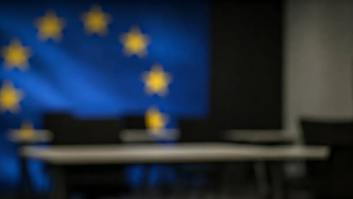 Imagen genérica de un espacio de coworking moderno, con mesas y sillas vacías, iluminado con luz suave.