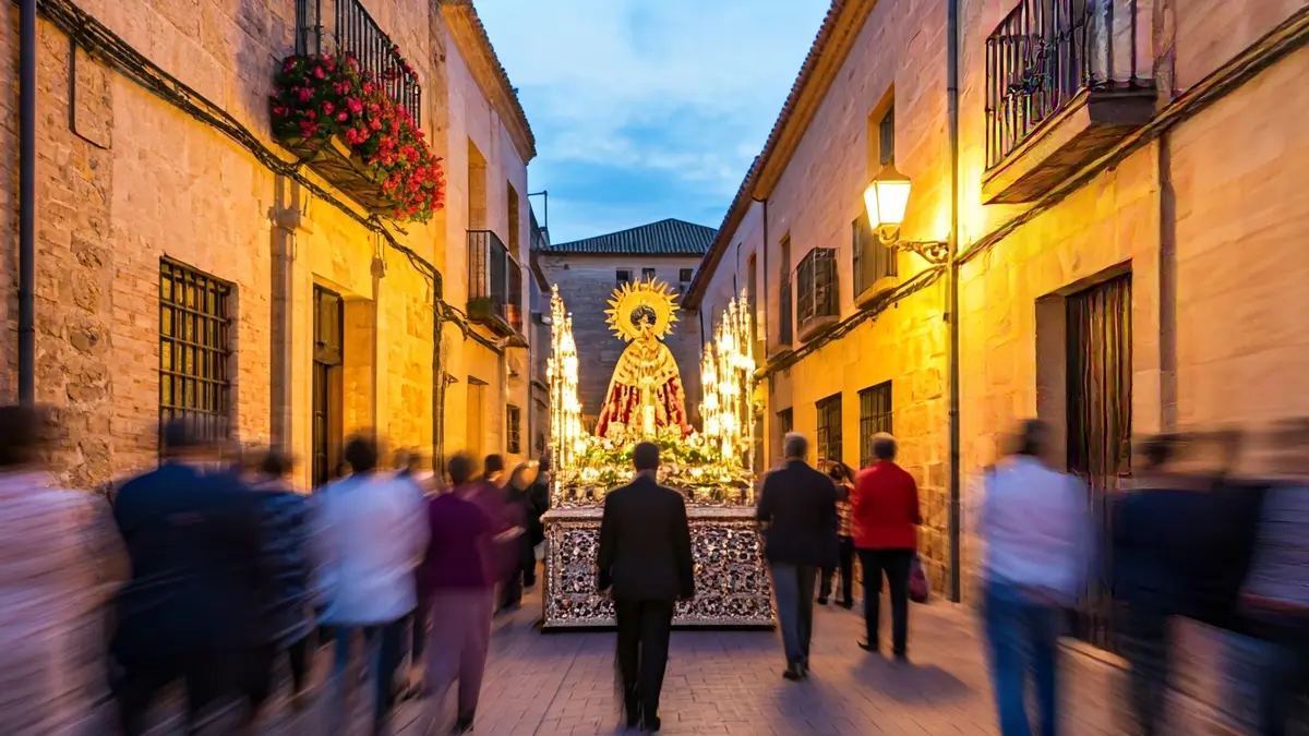 Image of a religious procession at dusk in a historic Andalusian city.
