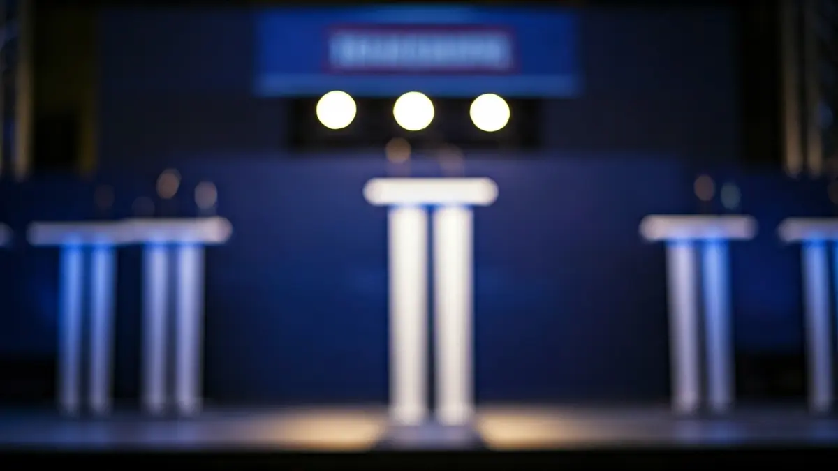 Generic image of an empty political debate stage with microphones.