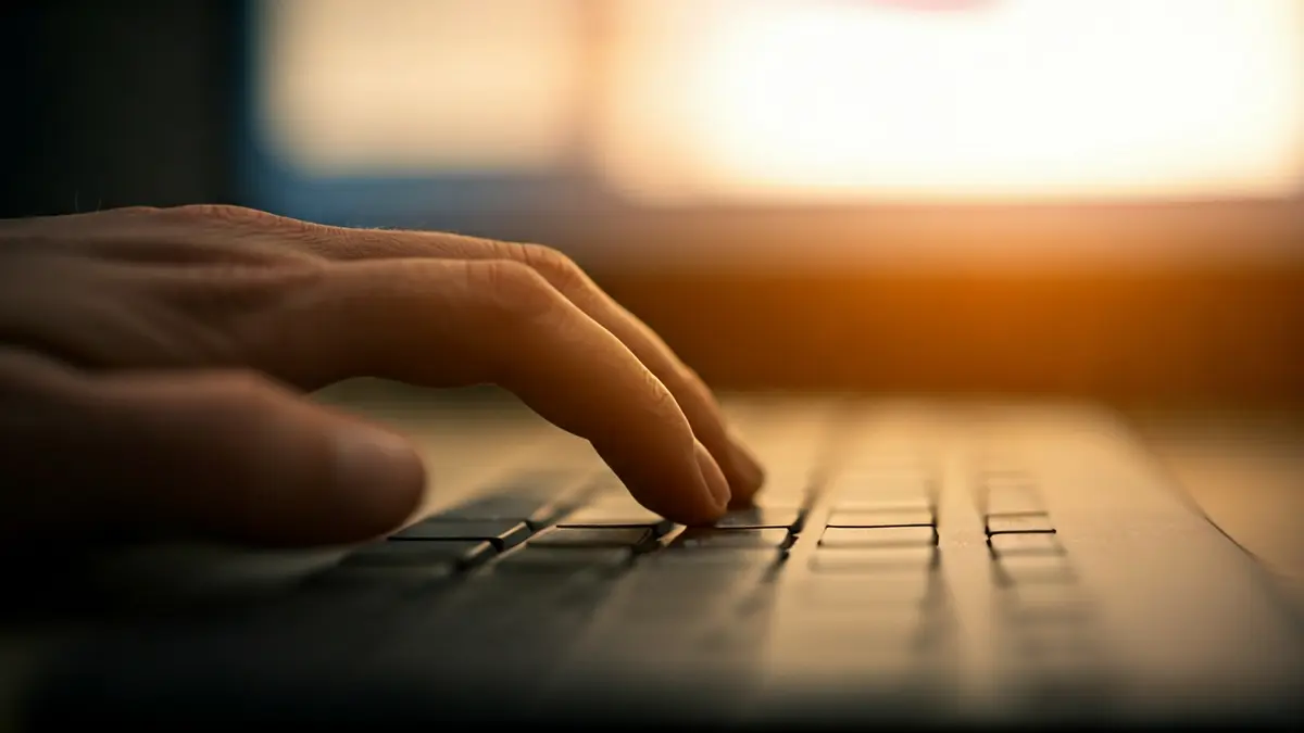 Imagen genérica de una persona usando un ordenador en el trabajo, con un calendario en la pantalla.