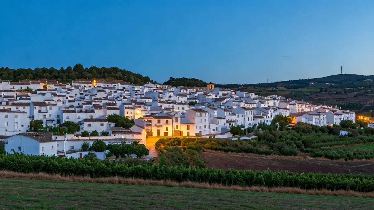 Image of an Andalusian village at dusk, with white houses and hills, symbolizing the fight against depopulation.