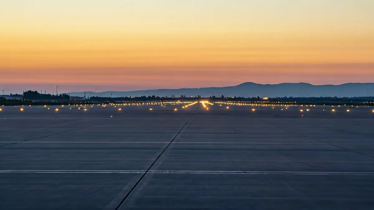 Image of an airport runway under construction at dawn.