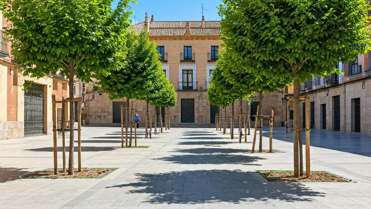 Image of a landscaped square with trees and green areas in an Andalusian city.