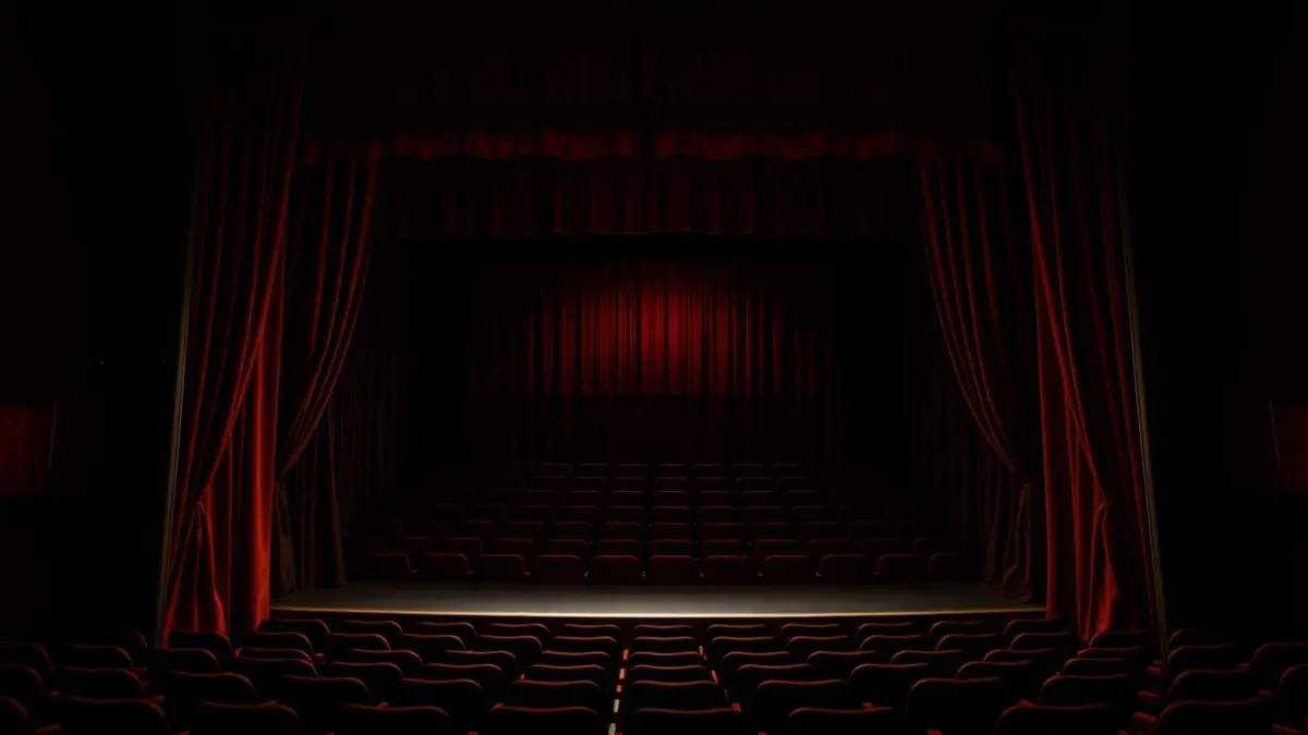 Generic image of a theater stage with red curtains.