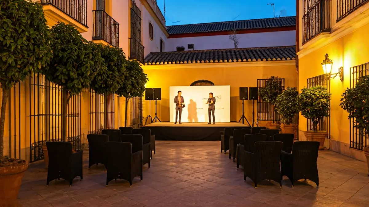 Patio de hotel en Sevilla preparado para un evento cultural al atardecer.