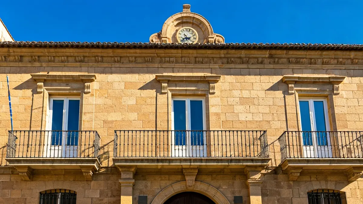 Facade of the Parliament of Andalusia, a Renaissance building with wrought iron balconies under sunlight.