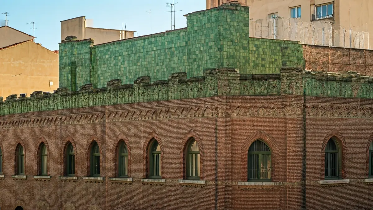 Facade of the former Florfé perfume factory in Jaén, with green tiles and modernist pinnacles.