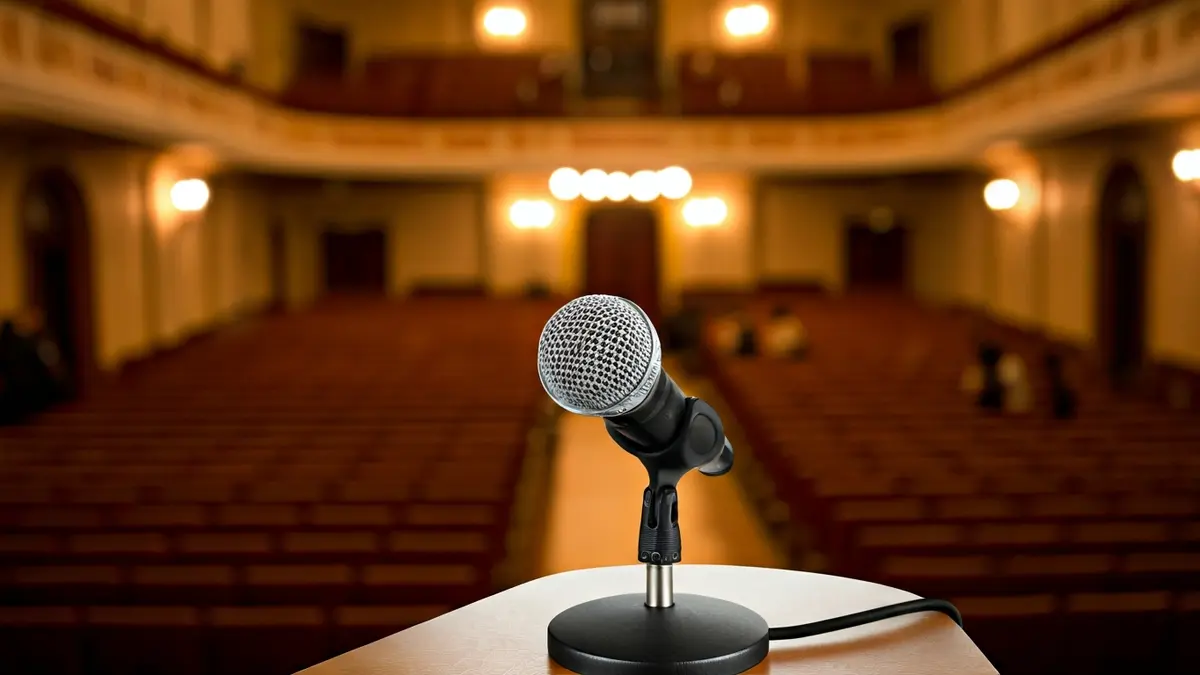 Imagen genérica de un micrófono en un podio, simbolizando un anuncio o evento cultural.