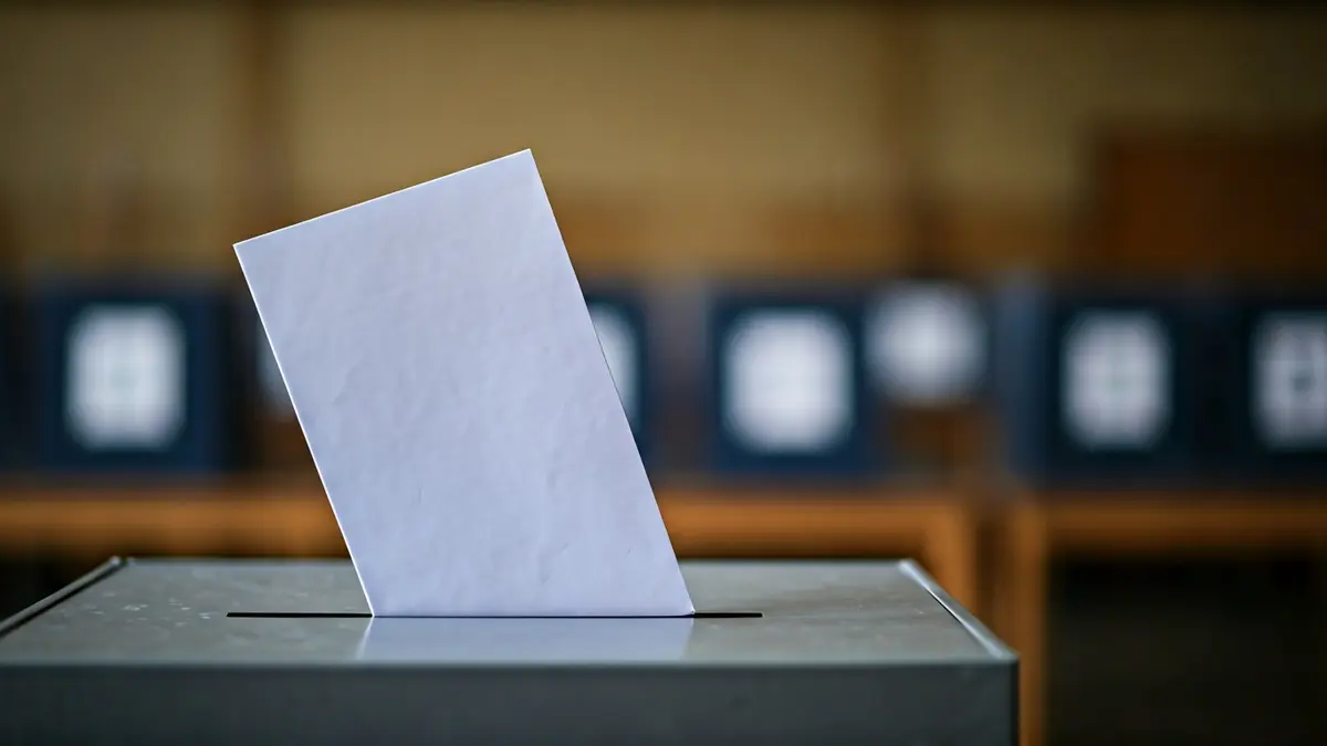 Imagen genérica de una urna electoral con papeletas, simbolizando el acto de votar.