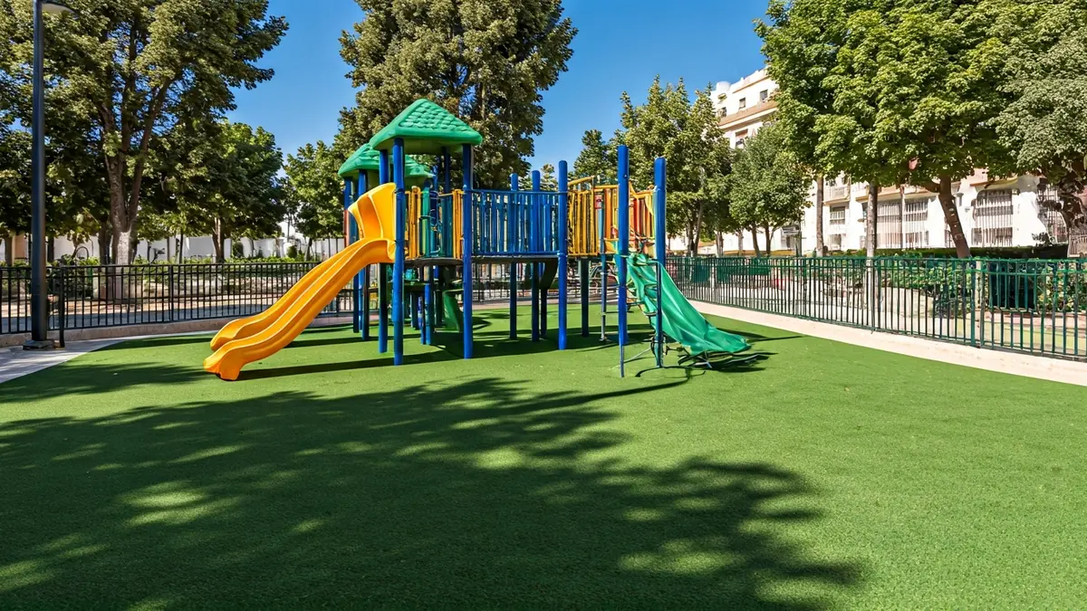 Imagen genérica de un parque infantil renovado con césped artificial y juegos coloridos.