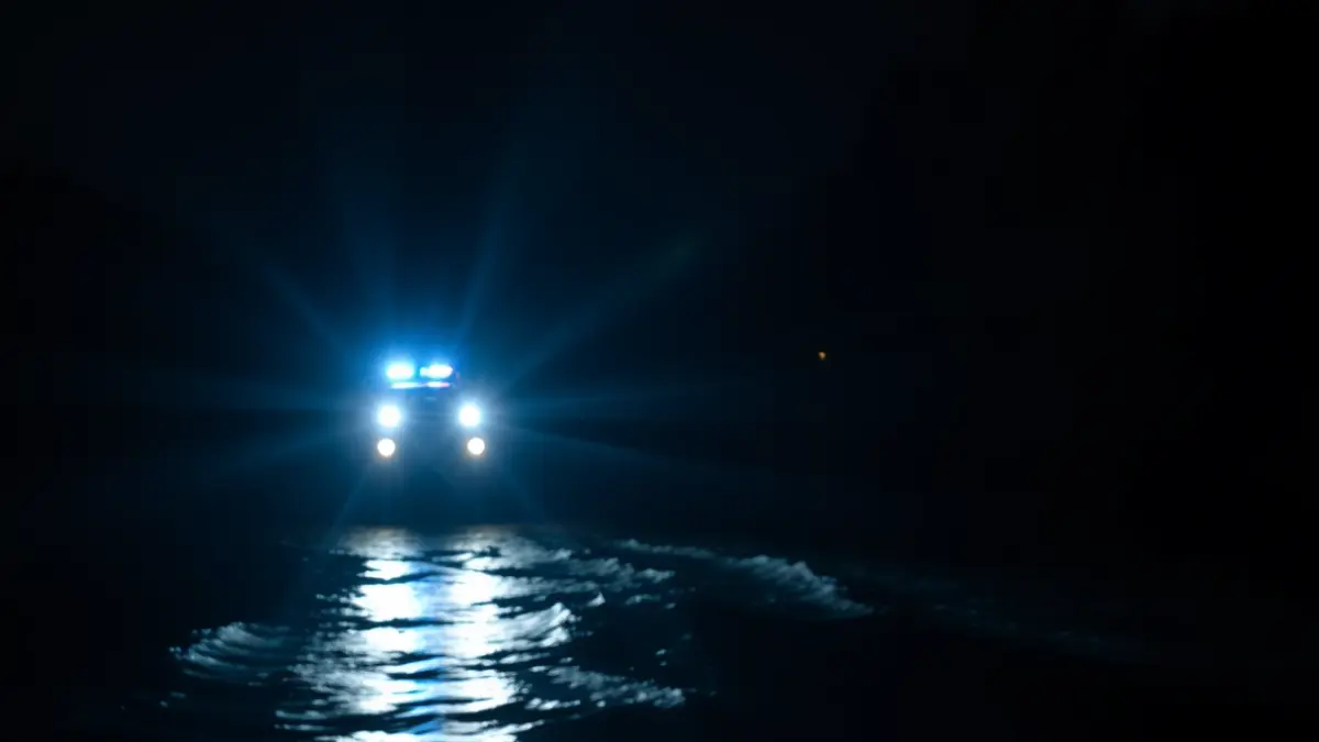 Generic image of emergency lights reflected on river water at night.