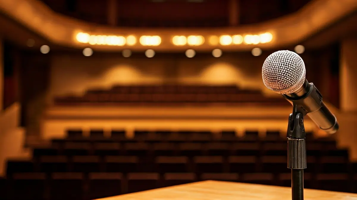 Imagen genérica de un micrófono en un podio, simbolizando un evento de charlas o conferencias.
