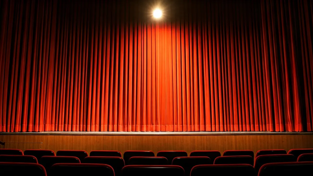 Imagen genérica de un escenario de teatro con cortinas rojas y un foco de luz.