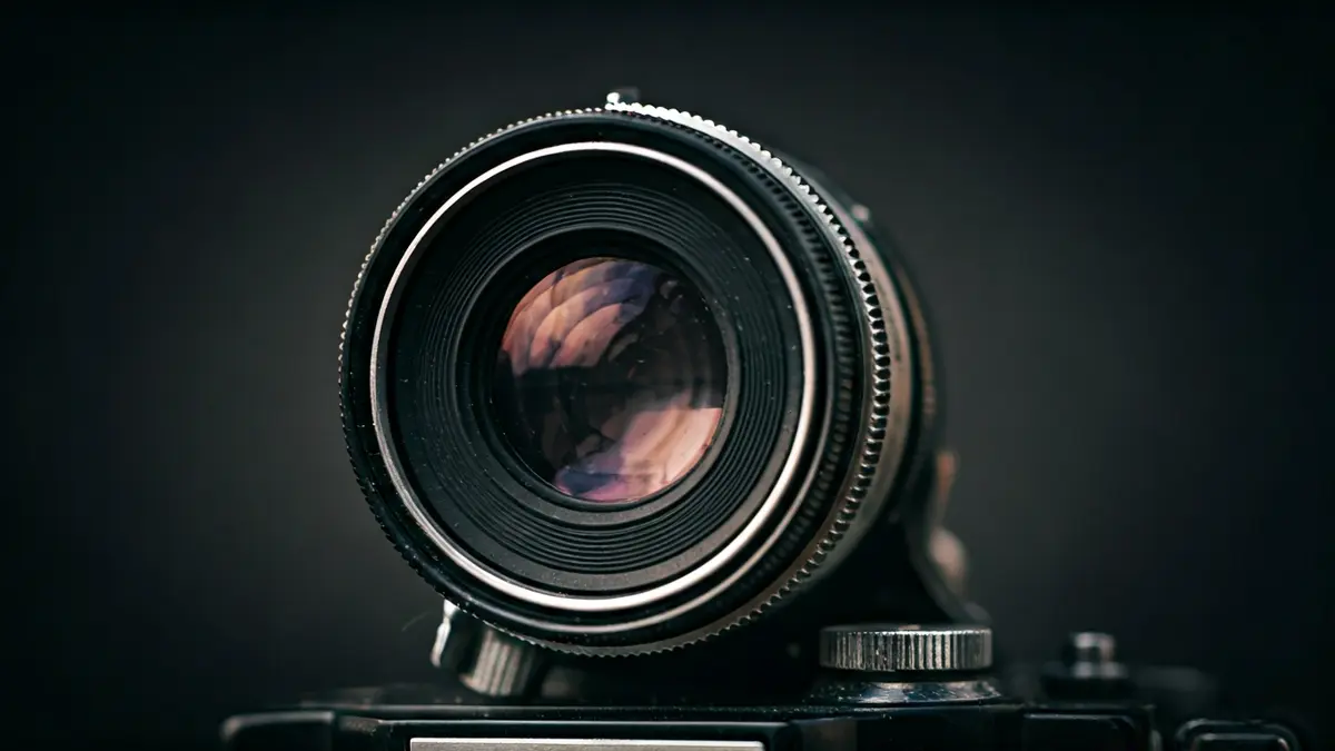 Generic image of a camera lens reflecting artistic photographs.