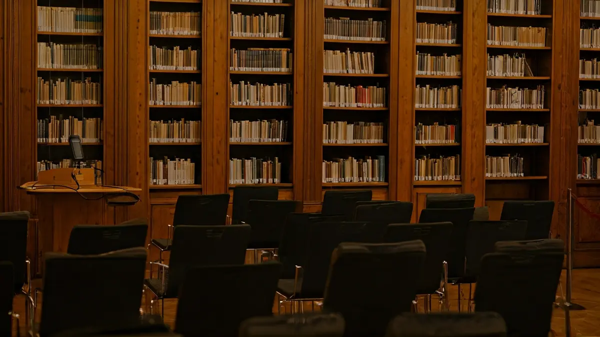 Imagen genérica de un interior de biblioteca con estanterías de madera y un podio con micrófono.