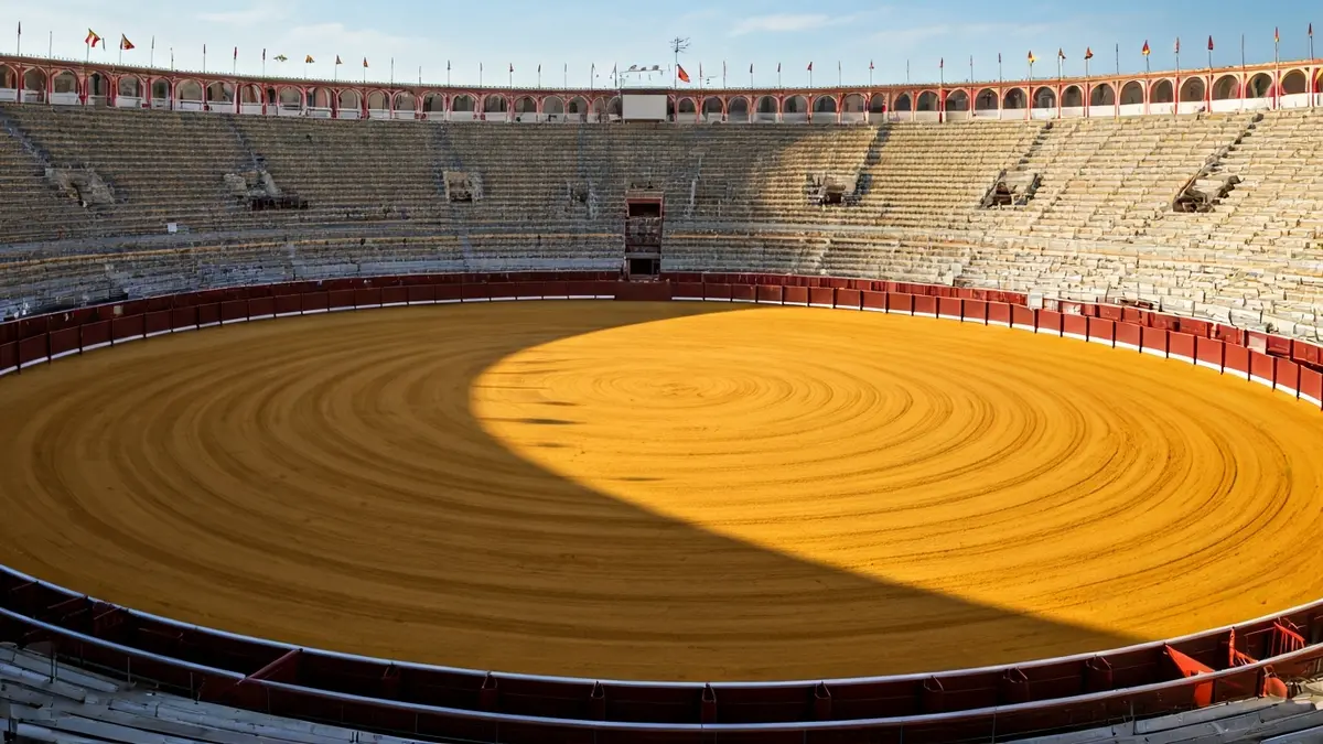 Imagen de una plaza de toros vacía bajo el sol, lista para un evento taurino.