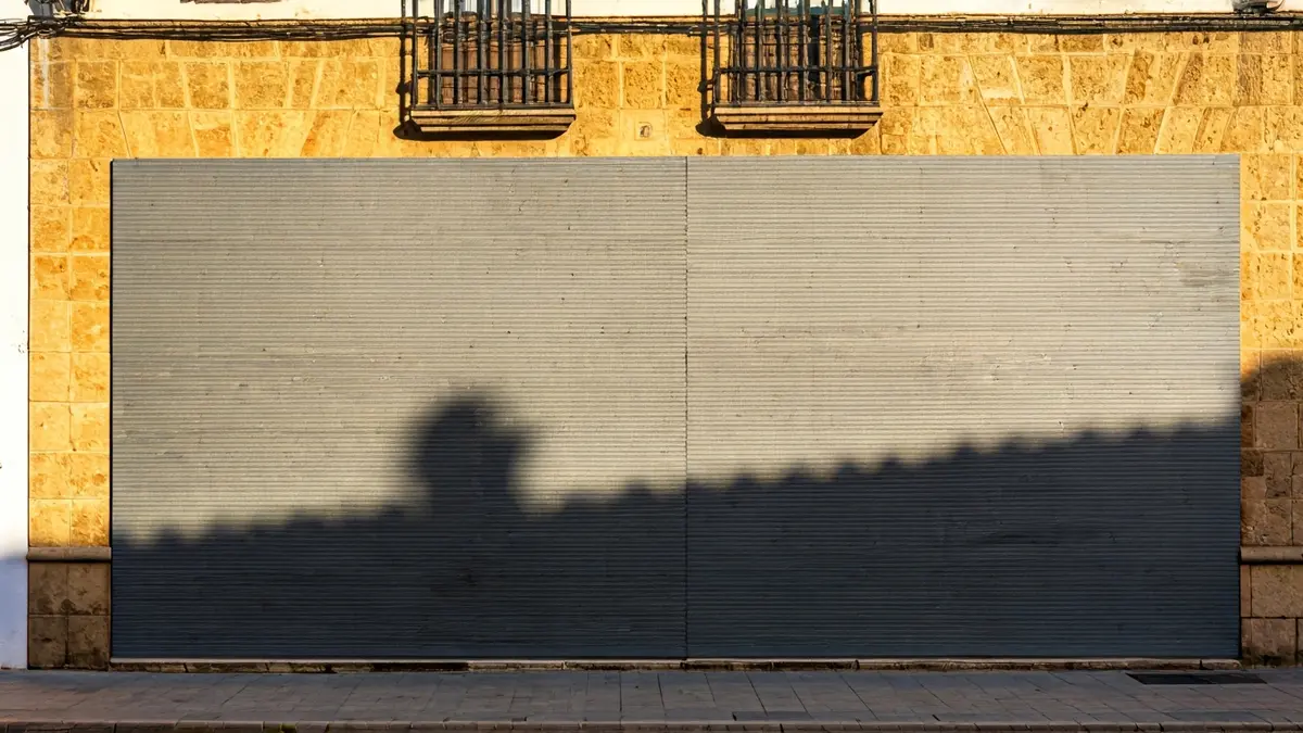Fachada de un edificio precintado y tapiado en una calle estrecha de Cádiz.