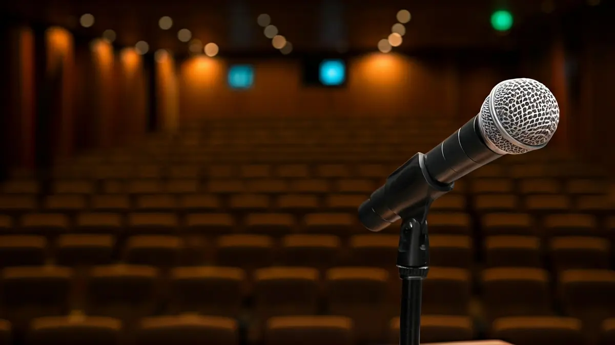 Imagen genérica de un micrófono en un podio en un auditorio, simbolizando un evento cultural o congreso.