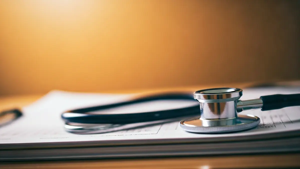 Imagen genérica de un estetoscopio sobre documentos médicos, simbolizando la carga laboral sanitaria.