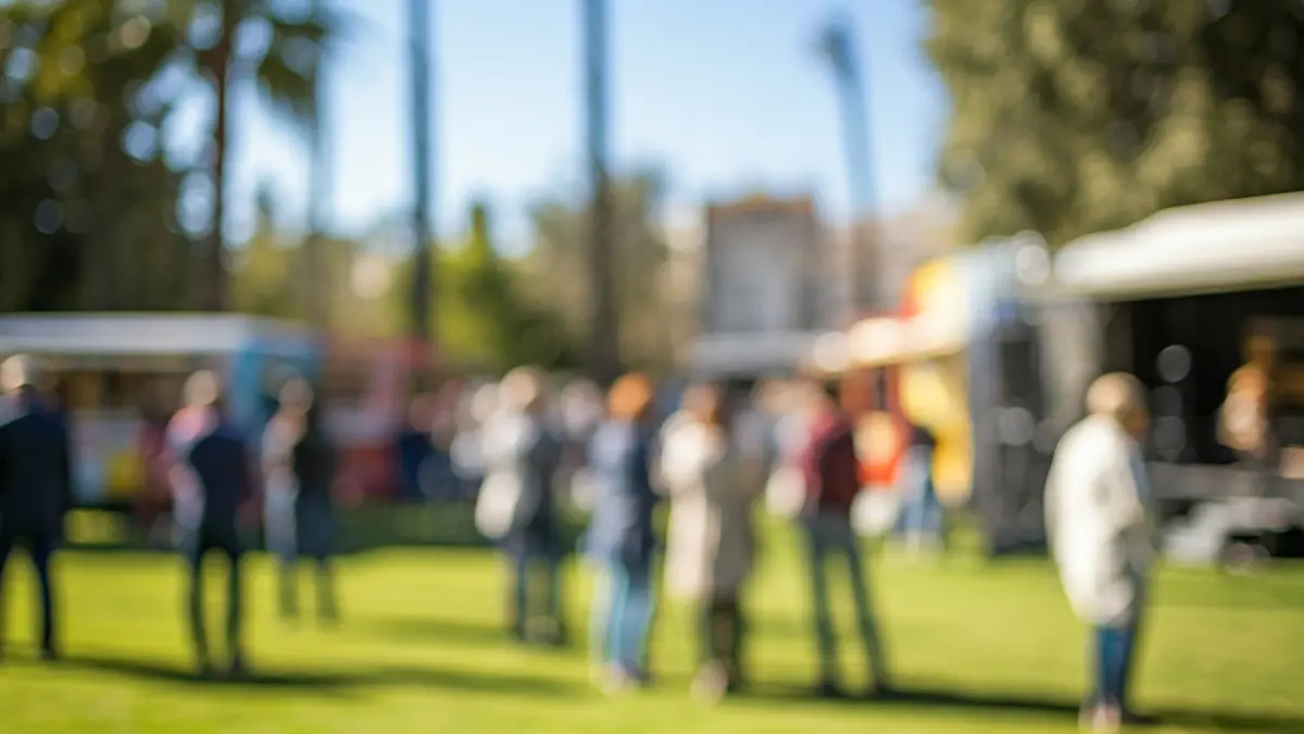Imagen genérica de un festival de primavera con food trucks y escenario en un parque.