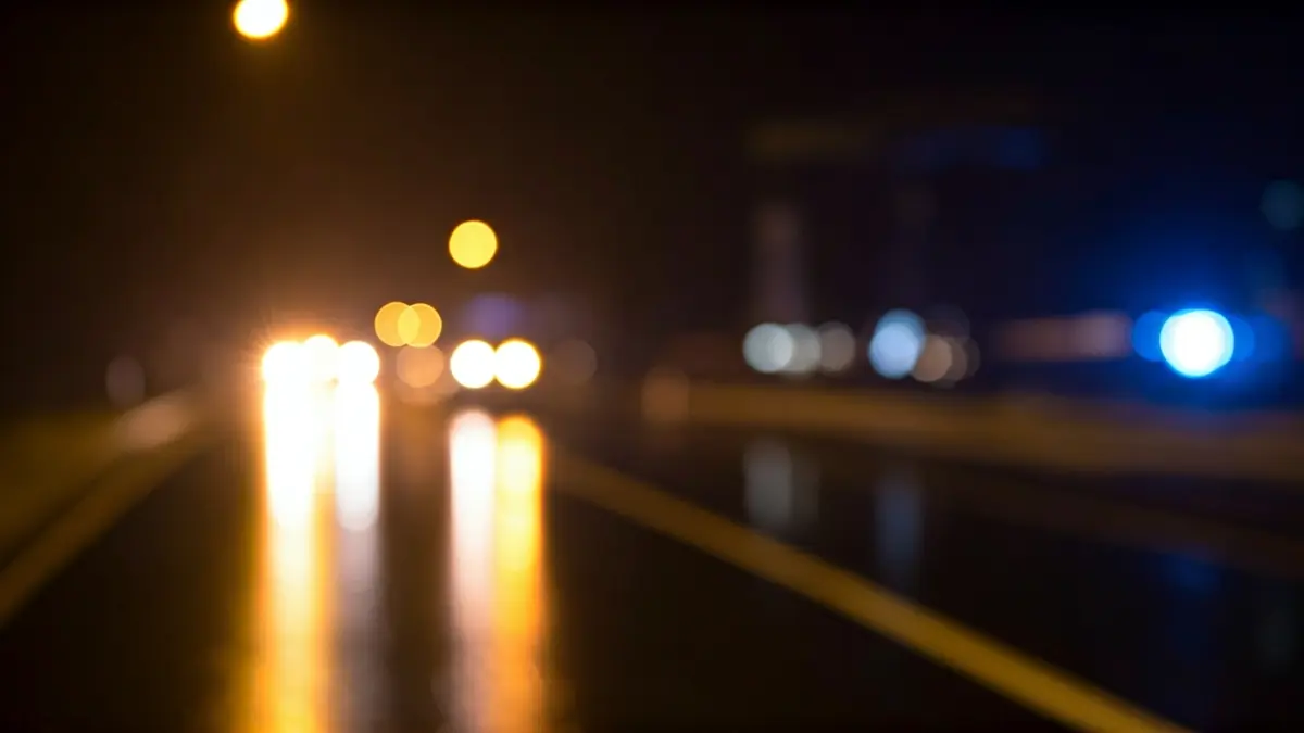 Generic image of emergency lights in the dark, reflected on wet asphalt.