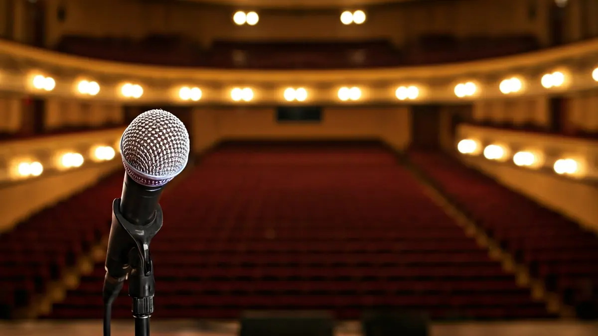 Imagen genérica de un escenario de concierto con un micrófono y luces.