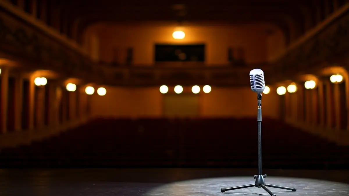 Imagen genérica de un escenario de teatro con un micrófono bajo un foco.
