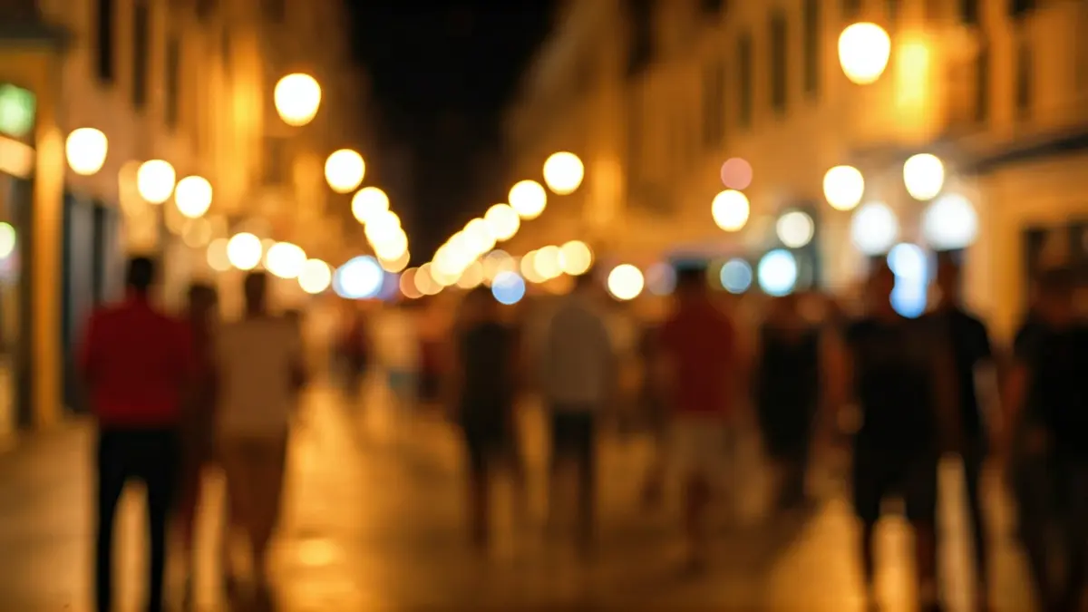 Generic image of a bustling street in a Mediterranean city at night, with blurred lights and a festive atmosphere.