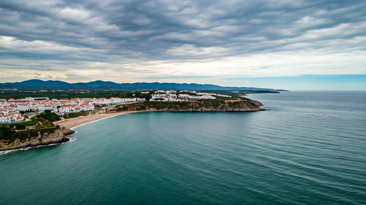 Aerial view of Tarifa's coastline under cloudy skies, showing the confluence of the Mediterranean and Atlantic.