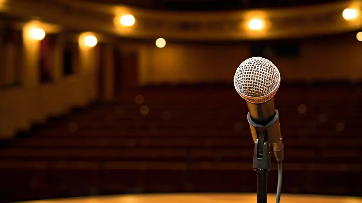 Imagen genérica de un escenario de teatro con un micrófono en un podio.