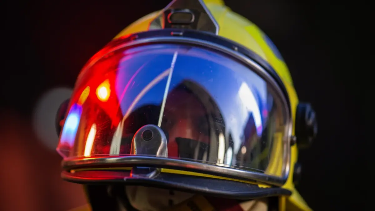 Generic image of a firefighter's helmet with emergency lights reflected.