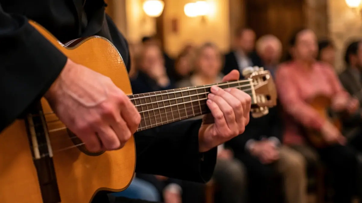 Close-up of flamenco guitarist's hands playing, with warm ambient lighting and a blurred background.