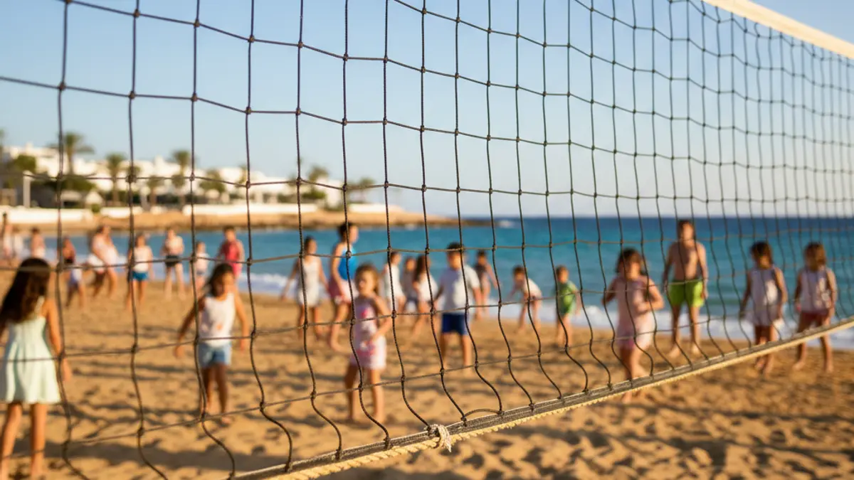Imagen genérica de una red de voleibol en una playa con niños jugando.