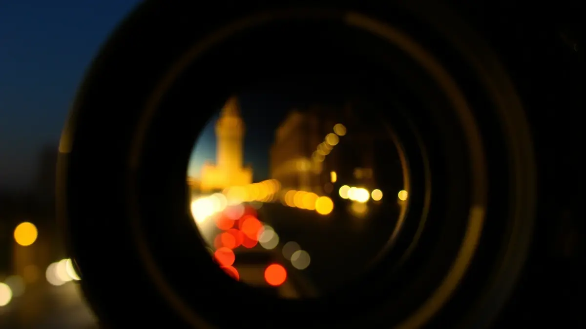 Imagen genérica de una cámara de cine, con luces de ciudad reflejadas en el objetivo.