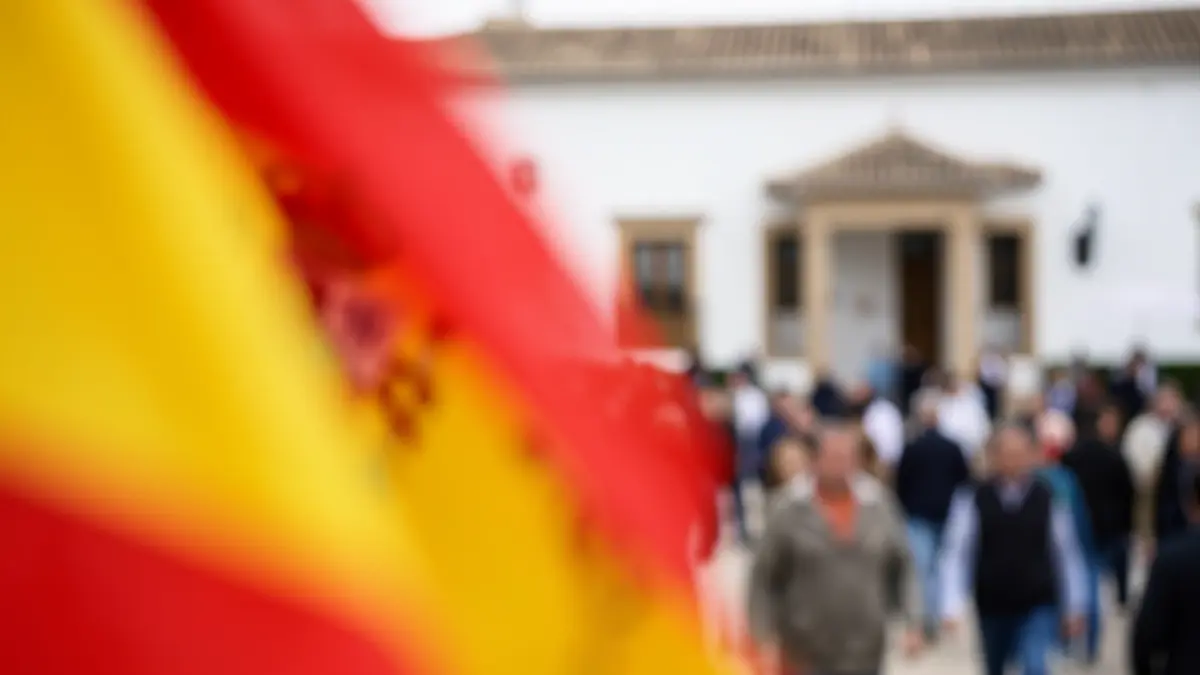 Generic image of Spanish flag colors with blurred Andalusian architecture.