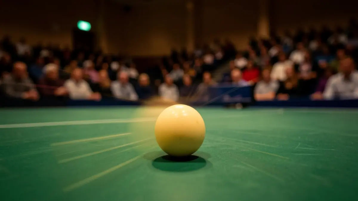Primer plano de una pelota de tenis de mesa en movimiento sobre una mesa verde, con un pabellón deportivo desenfocado al fondo.