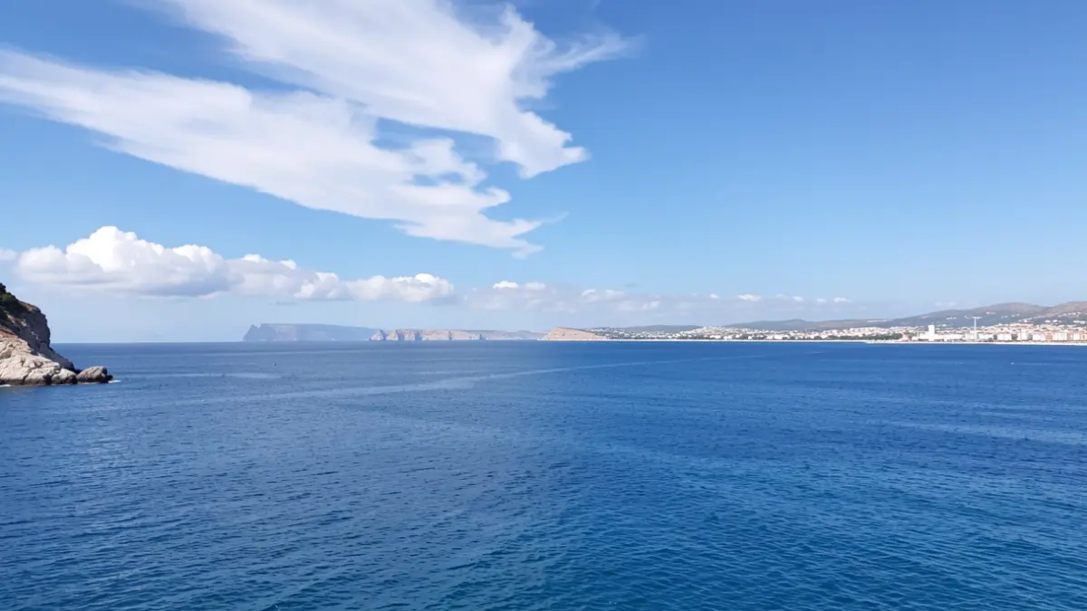 Cielo despejado sobre Tarifa con algunas nubes altas y el mar.