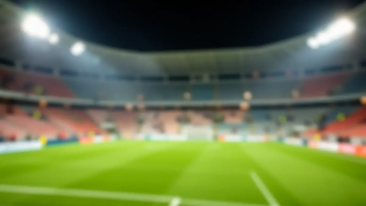 Imagen genérica de un estadio de fútbol por la noche, con el campo iluminado y asientos vacíos.