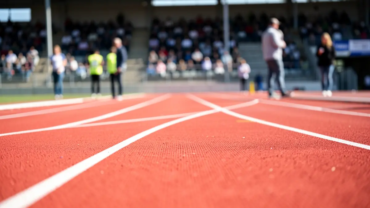 Generic image of a renovated athletics track with synthetic pavement and white lane markings.