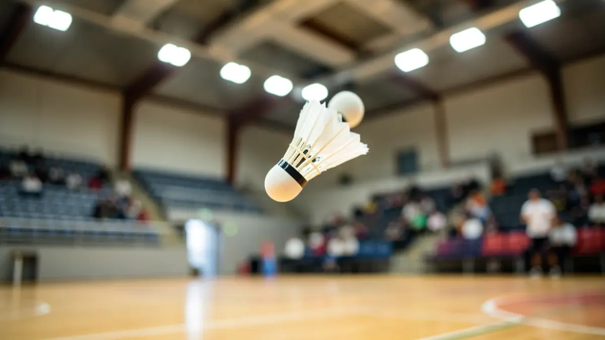 Imagen genérica de un volante de bádminton en el aire sobre una pista deportiva.