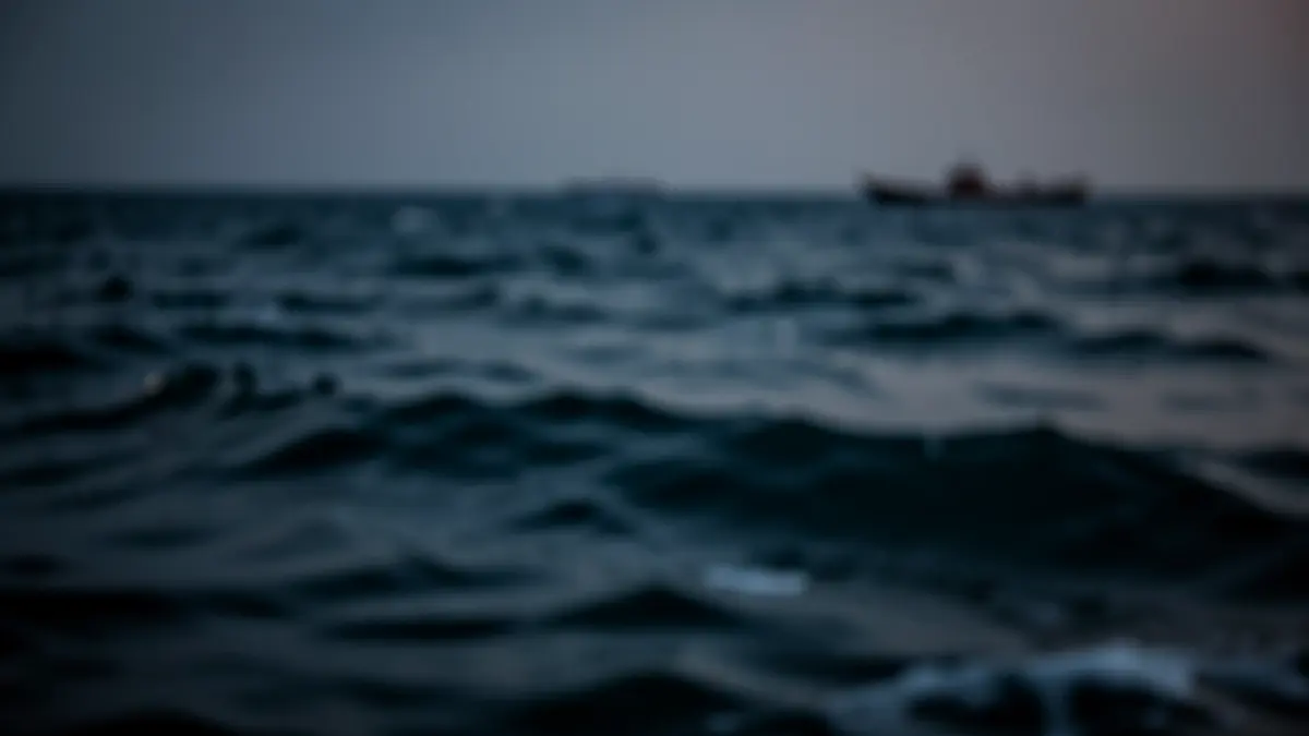 Generic image of Mediterranean sea waves at dusk with a distant boat silhouette.