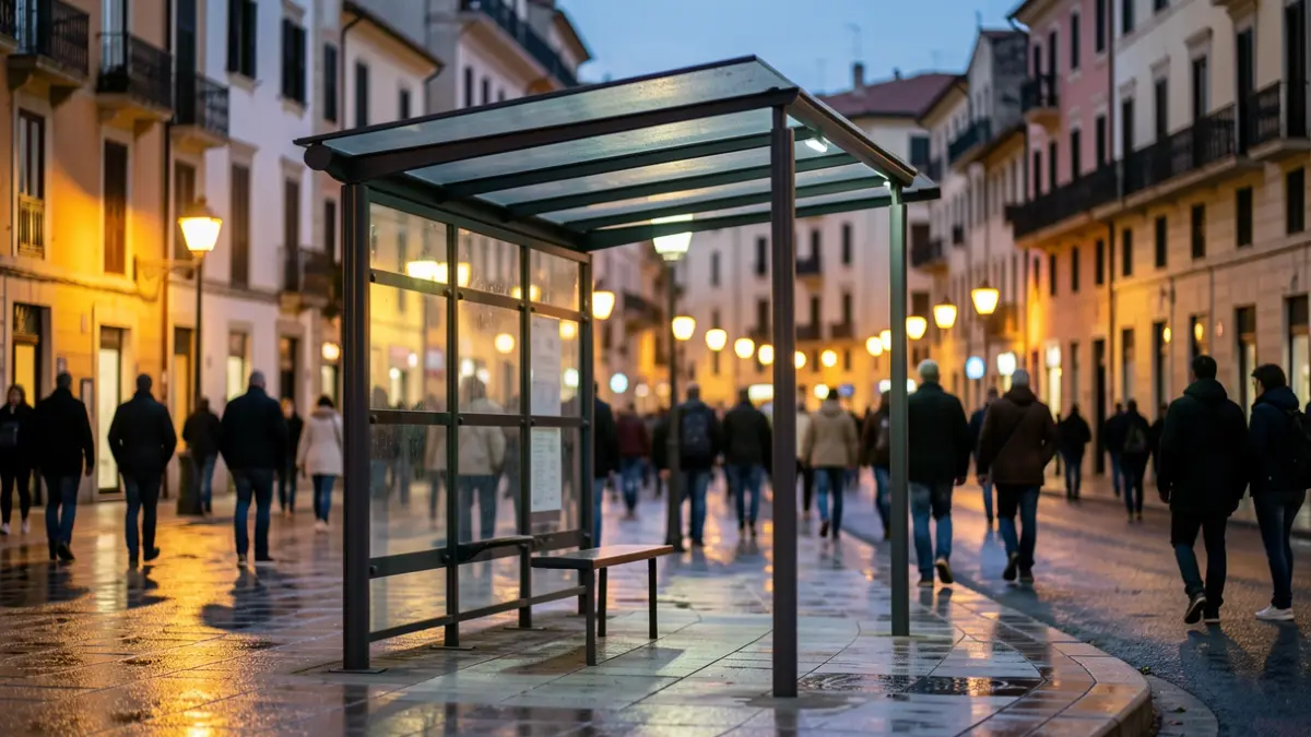Generic image of a modern bus stop with light reflections on the wet pavement.
