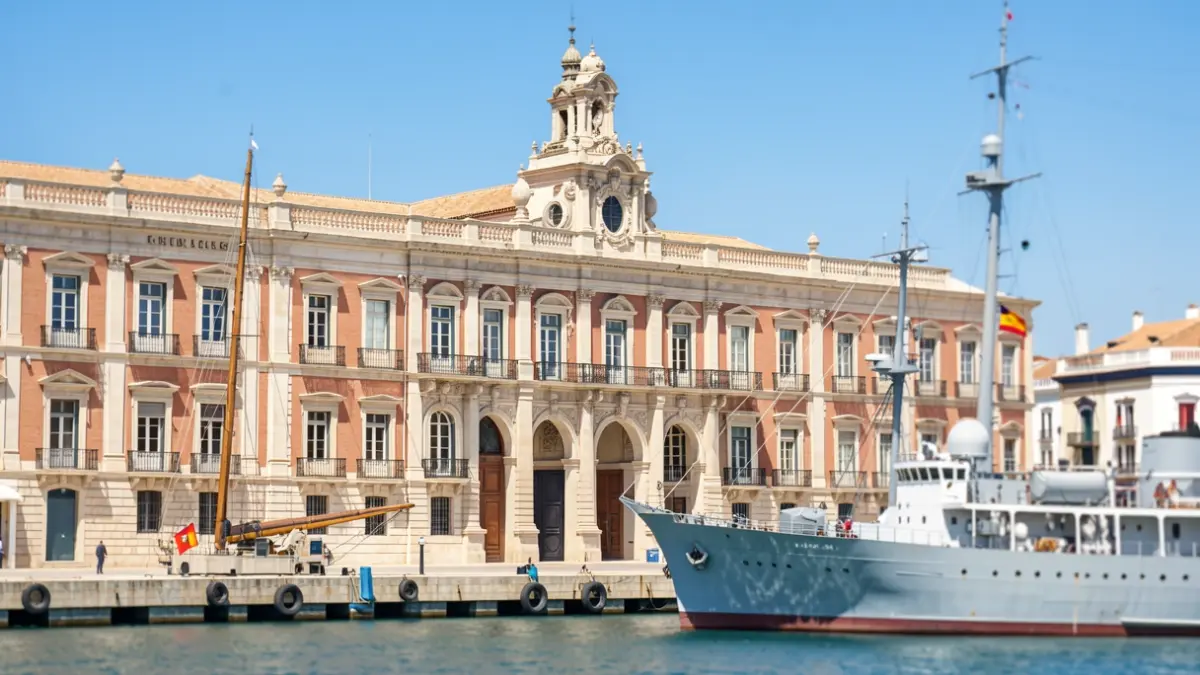 Facade of the Arsenal de La Carraca in San Fernando with the training ship Juan Sebastián de Elcano docked.