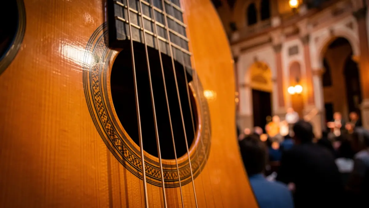 Primer plano de una guitarra clásica en un escenario con arquitectura andaluza.