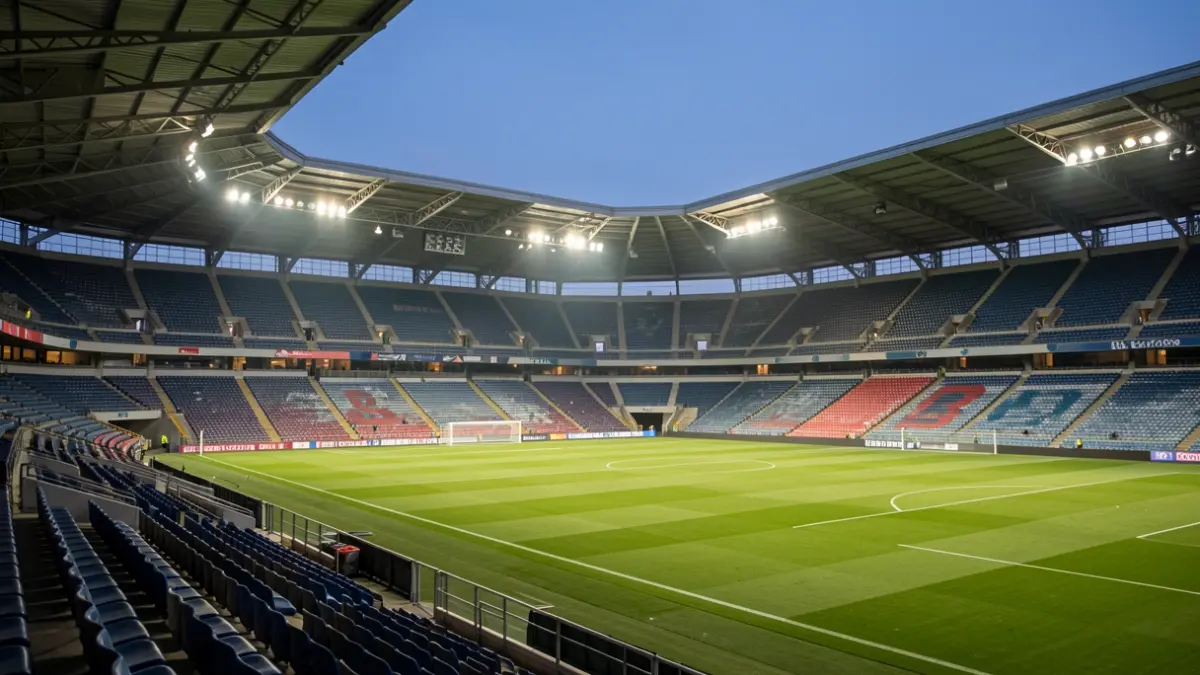 Generic image of a football stadium at dusk with the pitch illuminated.