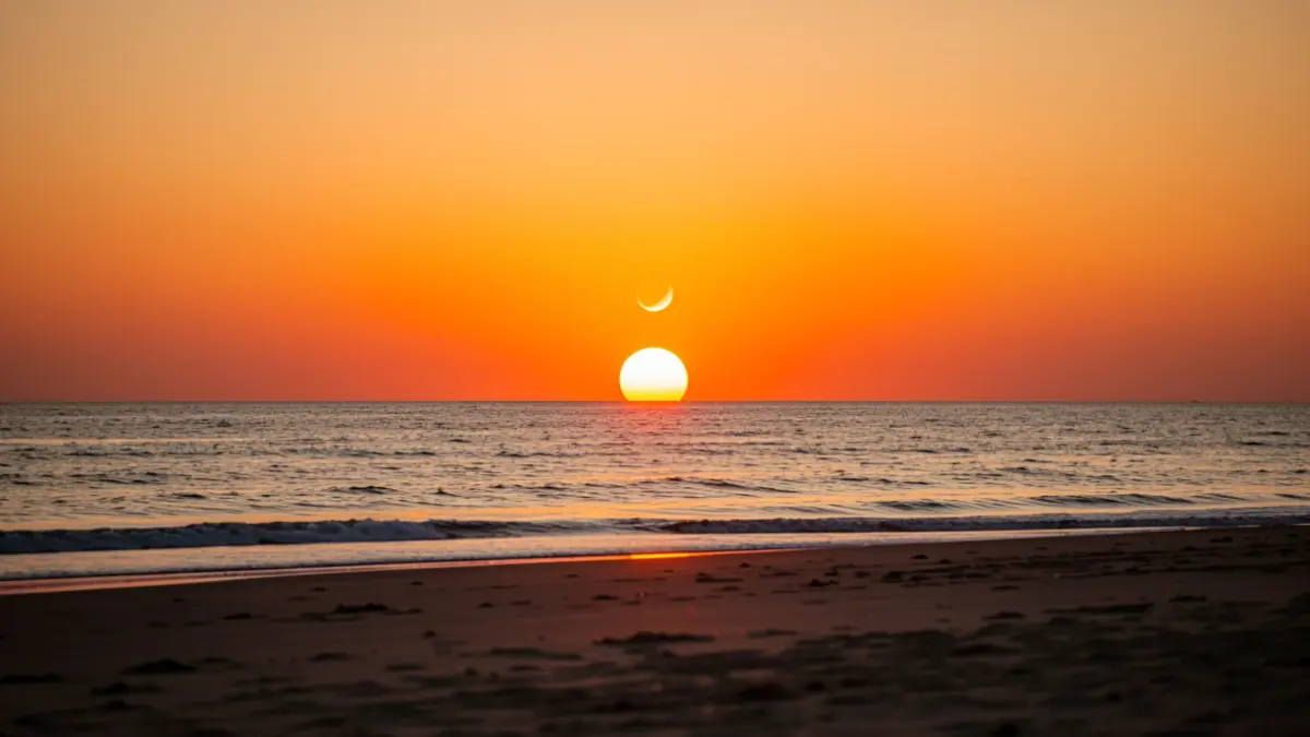 Playa de Camposoto al atardecer durante un eclipse solar parcial.