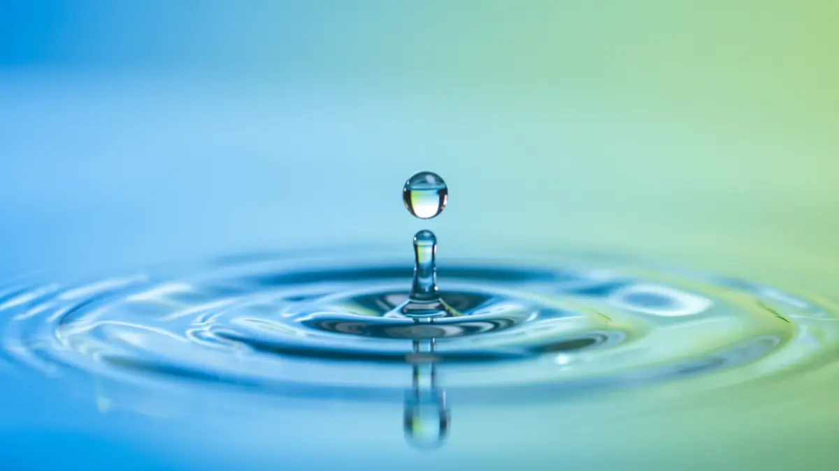 Imagen genérica de una gota de agua cayendo y creando ondas, con un fondo degradado azul y verde.