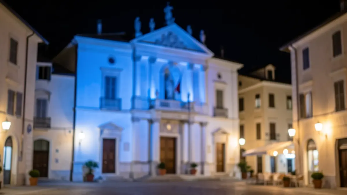 Generic image of a town hall facade illuminated in blue at night.